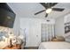 Relaxing bedroom includes a ceiling fan, mounted TV, and a charming vintage lamp at 4112 E Maldonado Dr, Phoenix, AZ 85042