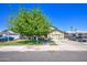 Inviting single-Gathering home showcases a lush green lawn and a mature shade tree enhancing its curb appeal at 4112 E Maldonado Dr, Phoenix, AZ 85042