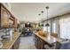 Open-concept kitchen featuring granite countertops, stainless steel appliances, and modern lighting fixtures at 4112 E Maldonado Dr, Phoenix, AZ 85042