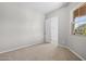 Bedroom showcasing neutral carpet, a window with a view, and an open closet door at 4320 E Bernice St, Gilbert, AZ 85295