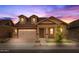Home exterior with a two-car garage, manicured landscaping, and a covered front porch at twilight at 4320 E Bernice St, Gilbert, AZ 85295
