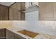 Modern kitchen featuring stainless steel appliances, stone countertops and a custom range hood at 4320 E Bernice St, Gilbert, AZ 85295