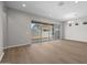 Open-concept living room boasts hard wood flooring, modern lighting and a sliding glass door at 4320 E Bernice St, Gilbert, AZ 85295