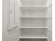 A well lit, white pantry with several shelves and an electrical panel inside this food storage space at 4320 E Bernice St, Gilbert, AZ 85295
