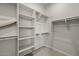 Bright, walk-in closet with carpet flooring, shelving and hanging rods for optimal storage and organization at 4320 E Bernice St, Gilbert, AZ 85295