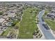 Neighborhood aerial view showcasing community park, mature trees, and residential homes at 44284 W Buckhorn Trl, Maricopa, AZ 85138