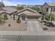 Aerial view of a home featuring desert landscaping, tiled roof, and two-car garage on a sunny day at 44284 W Buckhorn Trl, Maricopa, AZ 85138