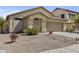 Well-maintained single-story home with a two-car garage and desert landscaping under a blue sky at 44284 W Buckhorn Trl, Maricopa, AZ 85138