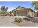 Well-maintained single-story home with a two-car garage and desert landscaping under a blue sky at 44284 W Buckhorn Trl, Maricopa, AZ 85138