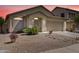 Well-maintained single-story home with a two-car garage and desert landscaping under a pink sky at 44284 W Buckhorn Trl, Maricopa, AZ 85138