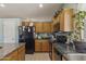 Well-lit kitchen with black appliances, wooden cabinets, and functional layout at 44284 W Buckhorn Trl, Maricopa, AZ 85138