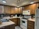 Eat-in kitchen features wooden cabinets and white appliances at 461 W Holmes Ave # 336, Mesa, AZ 85210