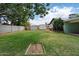 Large, grassy backyard featuring two storage sheds, a dog house, and horseshoe toss at 4744 W Altadena Ave, Glendale, AZ 85304