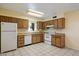 Well-lit kitchen featuring tile floors, white appliances, and wood cabinets at 4744 W Altadena Ave, Glendale, AZ 85304