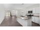 Open layout with an island kitchen, granite countertops, stainless appliances, and seamless flow into the living area at 47859 W Moeller Rd, Maricopa, AZ 85139