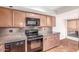 Traditional kitchen featuring wooden cabinets, granite countertops, and black appliances at 5102 N 31St Pl # 436, Phoenix, AZ 85016
