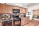 Well-lit kitchen featuring wood cabinets, granite countertops, and modern stainless steel appliances at 5102 N 31St Pl # 436, Phoenix, AZ 85016
