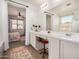 Bright bathroom features a vanity with ample counter space, vanity stool, and open doorway to bedroom at 531 S 198Th Ave, Buckeye, AZ 85326