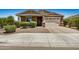 Charming single-story home with a well-manicured front yard, a stone-accented facade, and a two-car garage on a sunny day at 531 S 198Th Ave, Buckeye, AZ 85326