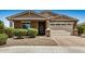 Charming single-story home with a well-manicured front yard, a stone-accented facade, and a two-car garage on a sunny day at 531 S 198Th Ave, Buckeye, AZ 85326