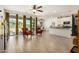Spacious living room with wood-look tile flooring, a ceiling fan, large sliding glass doors to the backyard, and an open layout at 531 S 198Th Ave, Buckeye, AZ 85326
