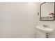 Modern powder room features a pedestal sink and mirror at 531 S 198Th Ave, Buckeye, AZ 85326