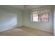 Serene bedroom featuring carpet and ample natural light from a large window at 5807 W Acoma Dr, Glendale, AZ 85306