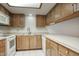 Functional kitchen featuring wood cabinets, white appliances, and ample counter space at 5807 W Acoma Dr, Glendale, AZ 85306