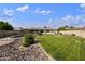 Expansive backyard featuring a lush lawn, rock landscaping, and a fenced pool for outdoor enjoyment at 6027 E Spring Rd, Scottsdale, AZ 85254