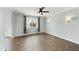 Bright bedroom featuring wood-look floors, a ceiling fan, and wall sconces for extra light at 6027 E Spring Rd, Scottsdale, AZ 85254