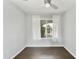 Well-lit bedroom with modern ceiling fan, wood-look floors, and backyard views at 6027 E Spring Rd, Scottsdale, AZ 85254