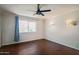 A bright bedroom with hardwood floors, a ceiling fan, and a window illuminating the space at 6027 E Spring Rd, Scottsdale, AZ 85254