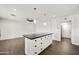Kitchen featuring a large island, modern pendant lighting, and convenient access to other areas of the home at 6027 E Spring Rd, Scottsdale, AZ 85254