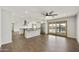 Open-concept living room with wood floors, a kitchen with stainless steel appliances, and sliding doors leading to a pool area at 6027 E Spring Rd, Scottsdale, AZ 85254