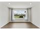 Bright room featuring wood floors, neutral walls, and a large window offering a view of the well-maintained backyard with a pool at 6027 E Spring Rd, Scottsdale, AZ 85254