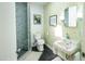 Unique bathroom with a glass enclosed shower, modern fixtures, and vintage-inspired wallpaper at 712 W Vernon Ave, Phoenix, AZ 85007