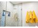 Bathroom features a glass enclosed shower with tiled walls, a rain shower head, and bright yellow towels at 712 W Vernon Ave, Phoenix, AZ 85007