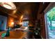 Spacious living room featuring exposed brick walls, wood ceilings, and a view of the lush backyard at 712 W Vernon Ave, Phoenix, AZ 85007