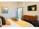 Bright main bedroom featuring a decorative yellow blanket, a modern cabinet, and lots of natural light at 712 W Vernon Ave, Phoenix, AZ 85007