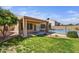 Lush backyard featuring a covered patio, pool with safety fence, and green grass at 7332 W Pershing Ave, Peoria, AZ 85381