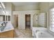 Bright bathroom featuring dual sinks, soaking tub, separate shower, and walk-in closet at 7332 W Pershing Ave, Peoria, AZ 85381