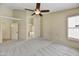 Spacious bedroom with neutral carpet, ceiling fan, and ensuite bathroom access at 7332 W Pershing Ave, Peoria, AZ 85381