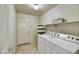 Functional laundry room with washer, dryer, storage shelves, and exterior door at 7332 W Pershing Ave, Peoria, AZ 85381