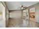 Spacious living room with a ceiling fan, tile flooring, and open access to the kitchen at 7332 W Pershing Ave, Peoria, AZ 85381