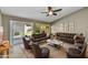 Spacious living room with vaulted ceilings, leather seating, and sliding glass doors to the backyard at 7332 W Pershing Ave, Peoria, AZ 85381