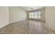Bright open room with tile flooring, ceiling fan, and large windows looking out to the backyard at 7332 W Pershing Ave, Peoria, AZ 85381