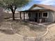 Desert landscaped backyard with an extended covered patio and a relaxing hot tub at 7415 S 16Th S Dr, Phoenix, AZ 85041