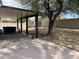 Large, shady backyard with extended covered patio, desert landscaping, and a hot tub at 7415 S 16Th S Dr, Phoenix, AZ 85041