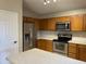 Kitchen showcasing stainless steel appliances, oak cabinetry, and efficient layout at 7415 S 16Th S Dr, Phoenix, AZ 85041