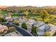 Stunning aerial view of homes and a golf course with mountain views in the distance at 7425 E Gainey Ranch Rd # 13, Scottsdale, AZ 85258